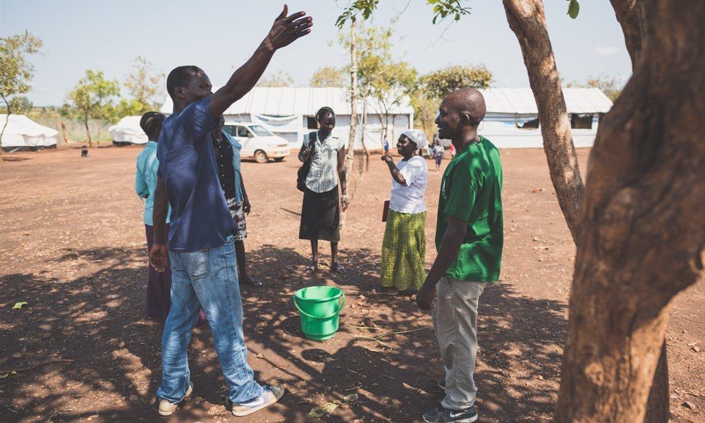 Group of people talking by a tree